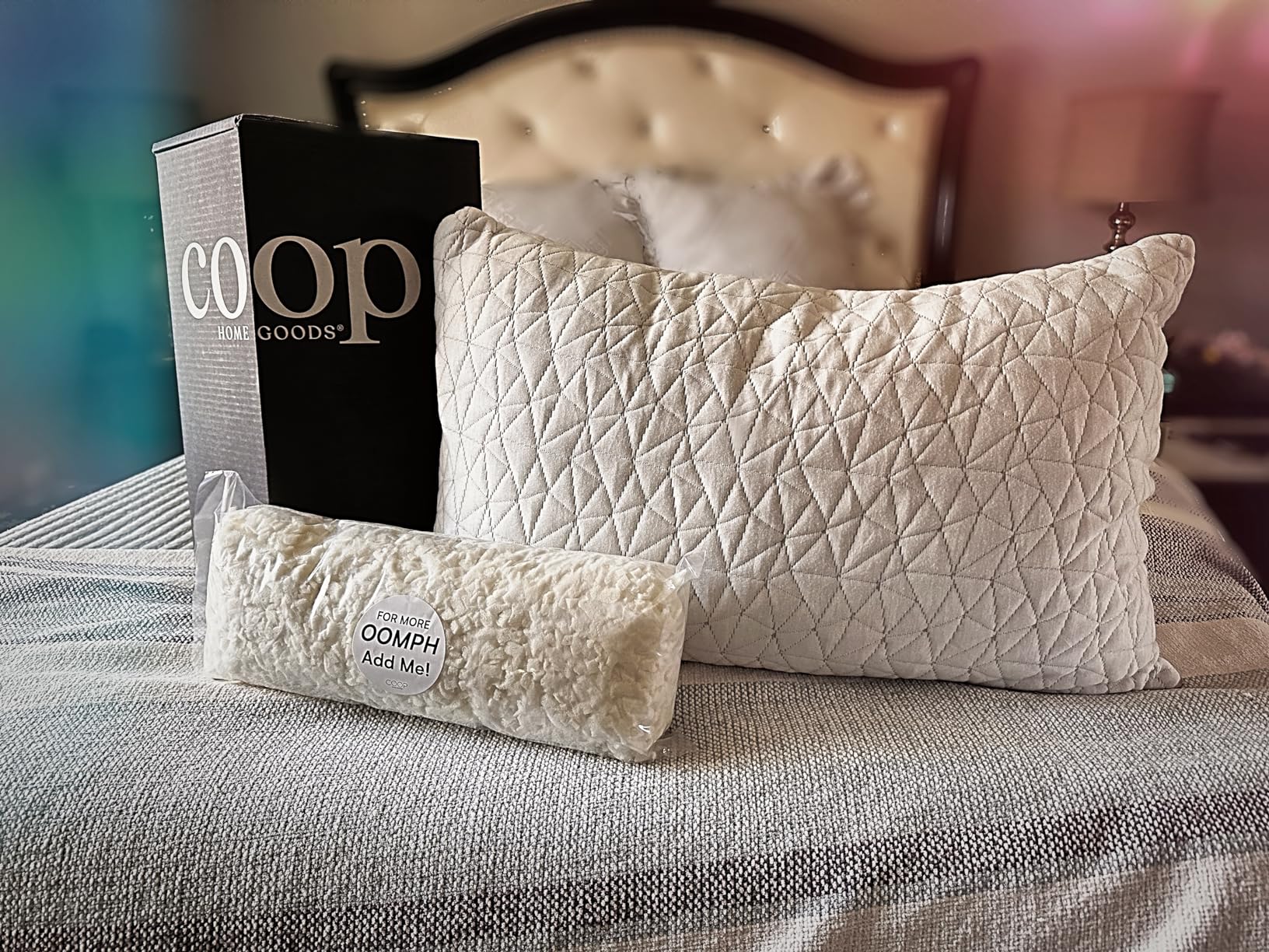 A Coop Home Goods pillow sits on a bed with its box and extra filling, showing the Coop Home Goods Original Adjustable Pillow, Queen Size Bed Pillows in use for a product review and featured in the 10 Most Recommended Pillows.