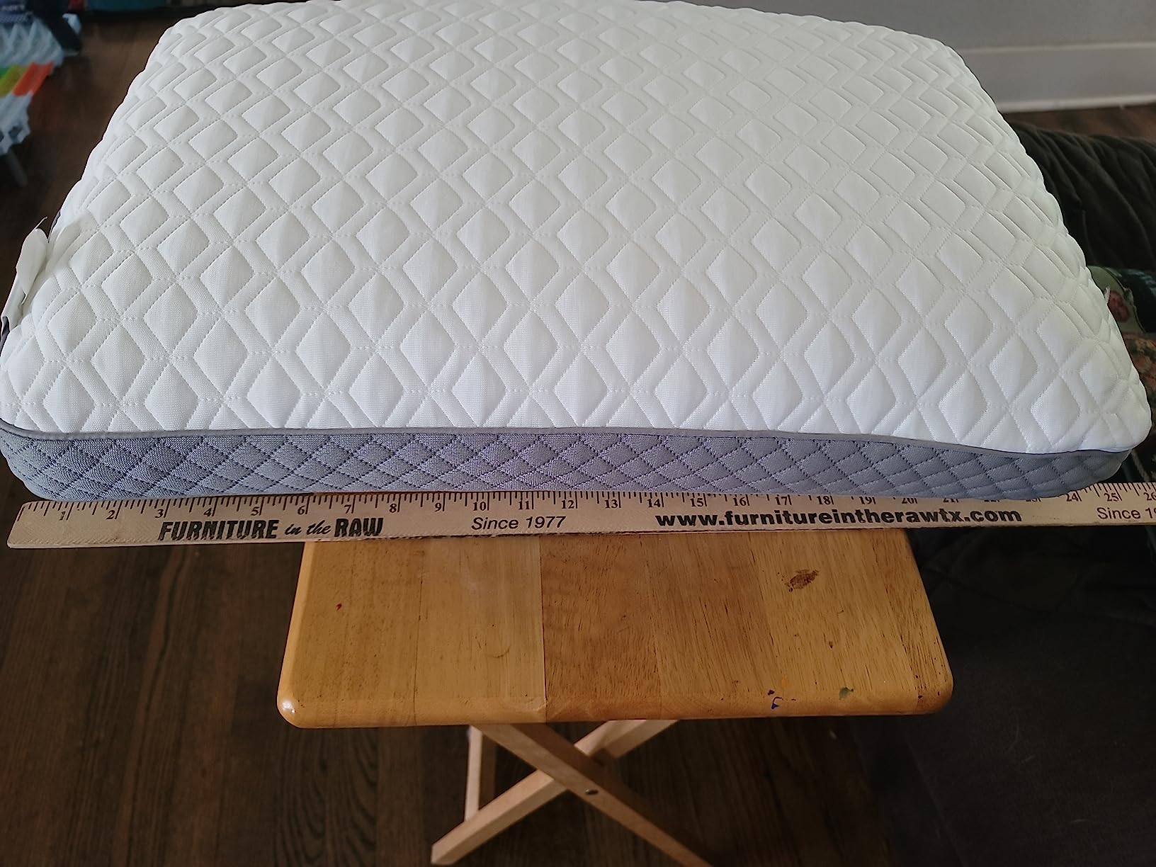 A Sealy Molded Bed Pillow is shown on a table, with a ruler on top to illustrate its dimensions for a product review.