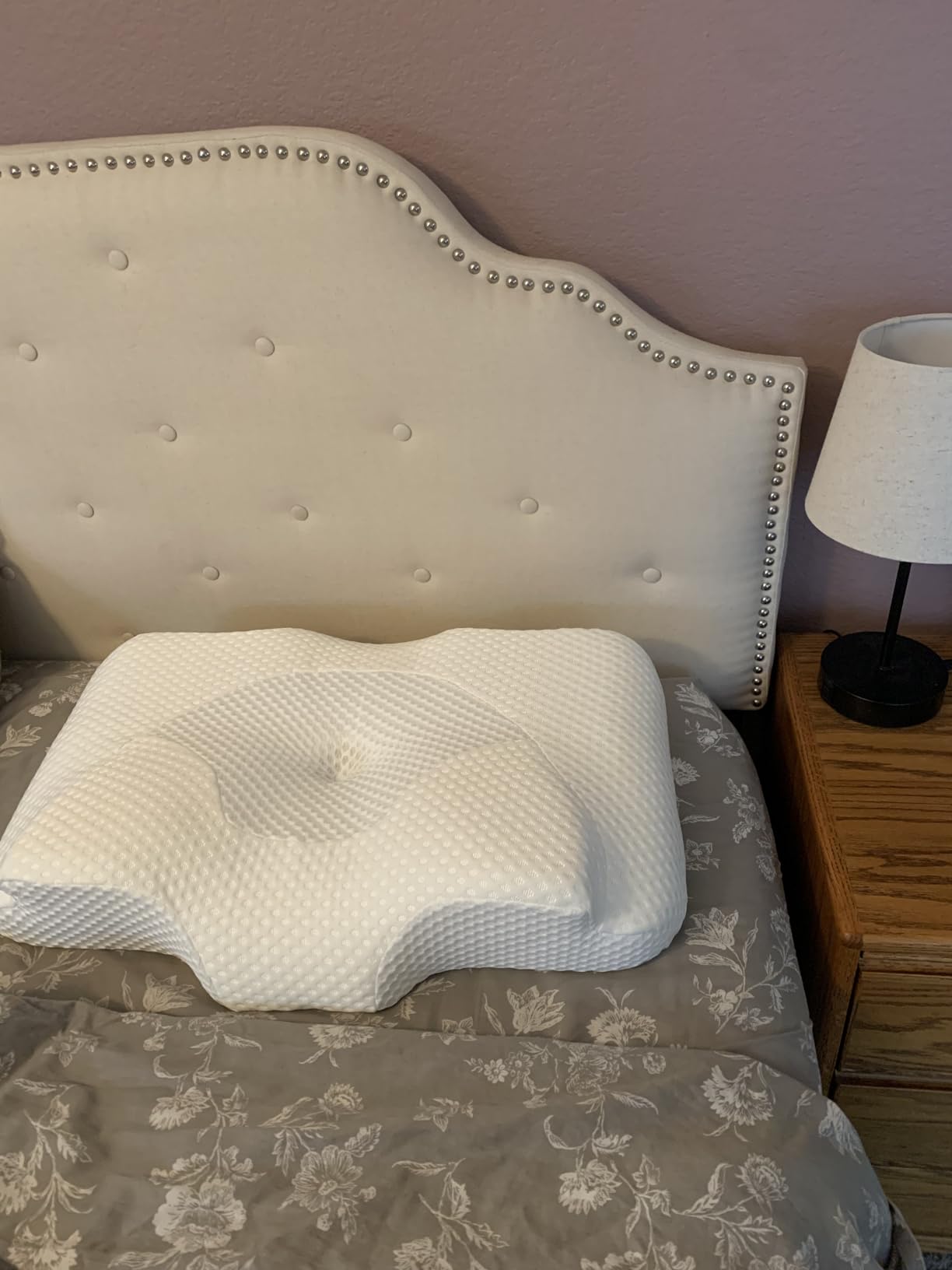 A bed with an Osteo Cervical Pillow resting on top, showcasing its comfort and support for a restful sleep.