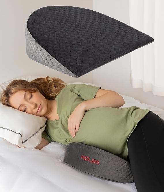 A woman resting on her back with a pillow, using the Kolbs Wedge Pregnancy Pillow for comfort and support.