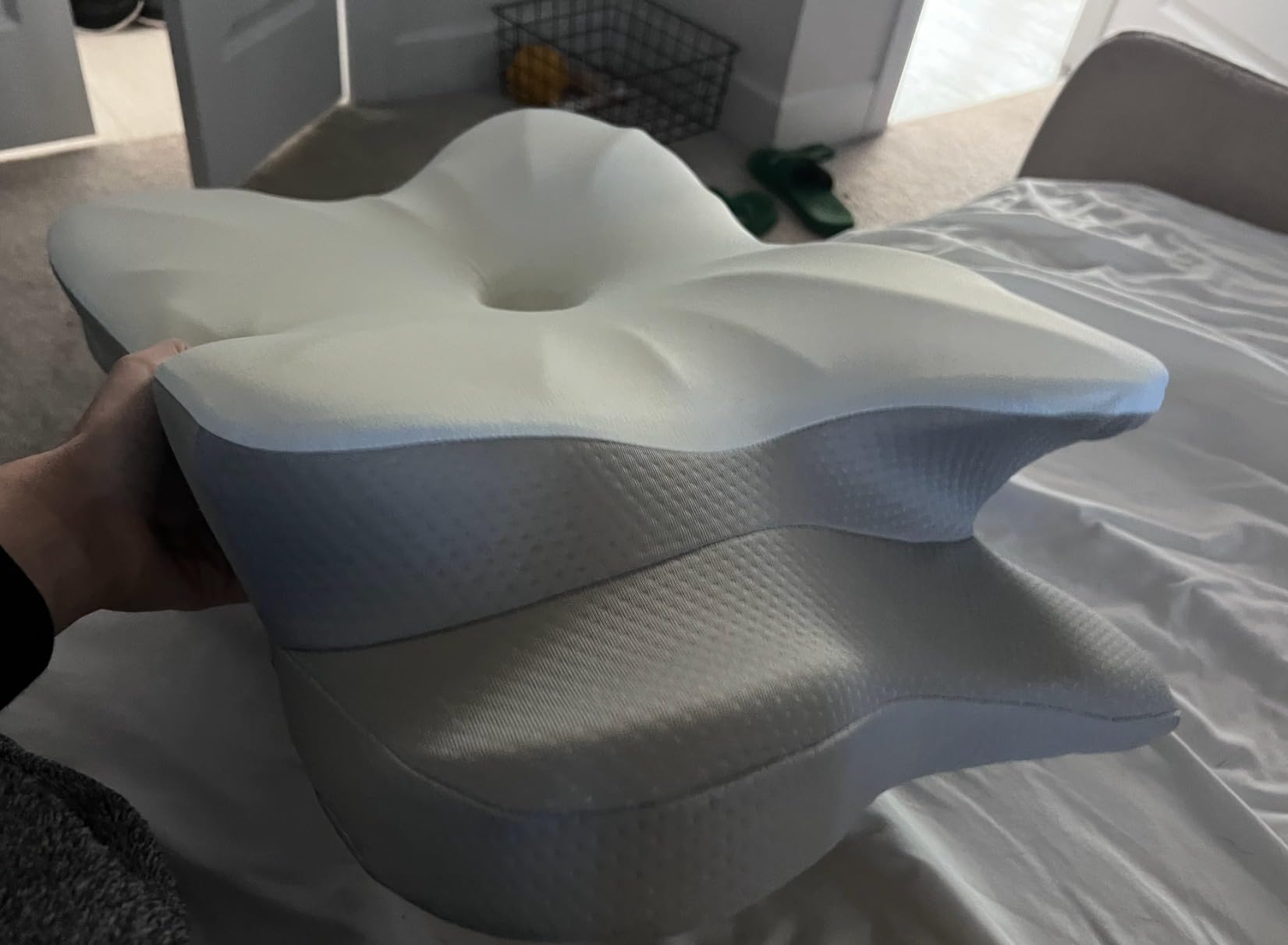 A person is seen with the DONAMA Cervical Pillow, made from foam, illustrating its design and comfort for a product review.