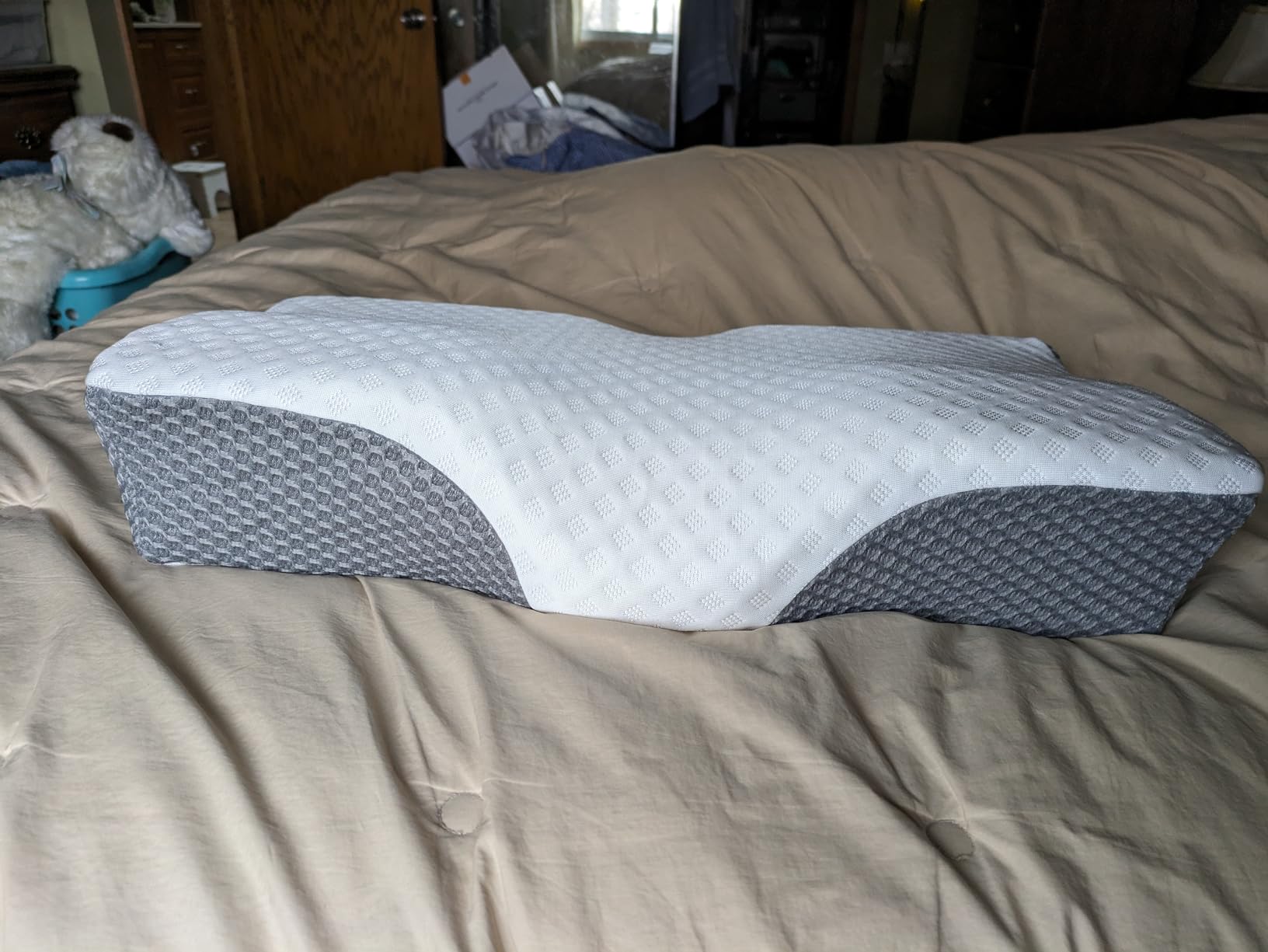 The Groye Adjustable Pillow placed on a bed, highlighting its cozy appearance and suitability for a product review.